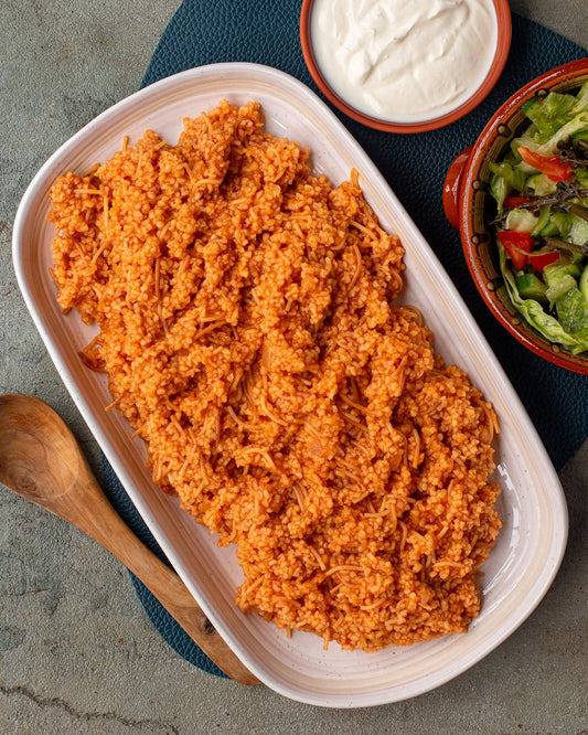 Bulgur pilaf in a plate with a side of salad and yoghurt